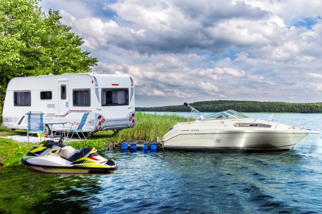 RV and boat at a scenic lakeside campsite at sunset